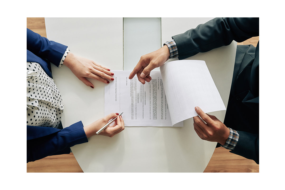 two people signing an employment contract, a legal contract